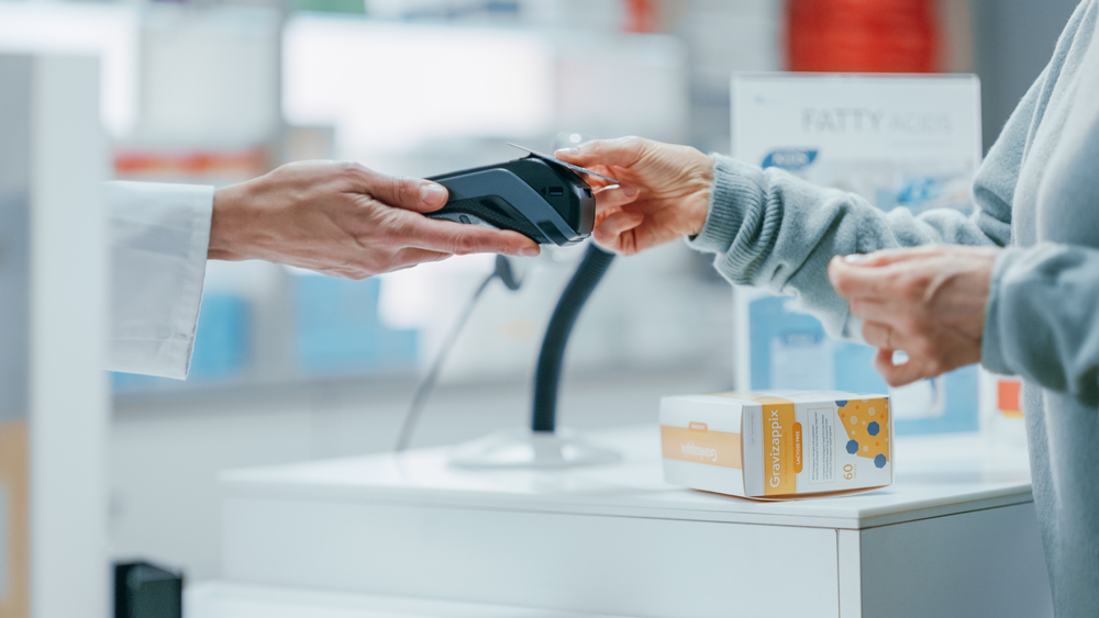 Customer uses card to pay for health care goods at pharmacy.